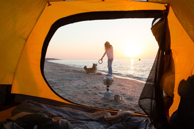 Fröhliches Spaßwochenende am Meer - Mädchen, das mit einem Hund am Strand spielt. Sommer