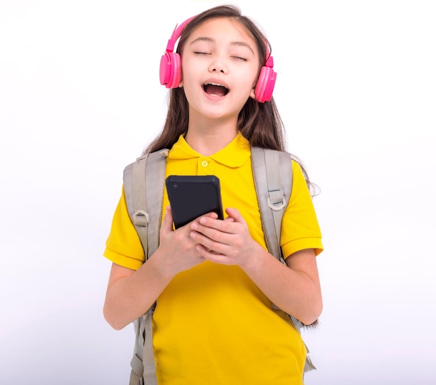 Fröhliches Studentenmädchen, das mit Kopfhörern Musik hört und ein Lied singt