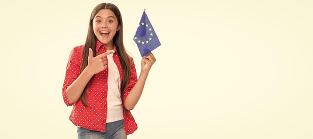 Fröhliches Teenager-Mädchen, das mit dem Finger auf die Flagge der Europäischen Union zeigt Schengen-Länder Touristenvisum Banner der Schulmädchen-Studentin Schulmädchen-Schülerporträt mit Kopierraum