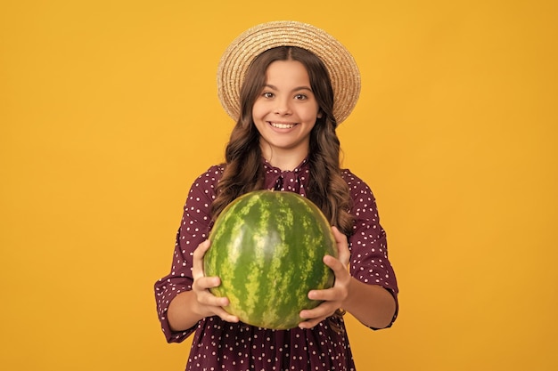 Fröhliches Teenager-Mädchen, das sich im Sommer amüsiert, hält Wassermelone Wassermelone
