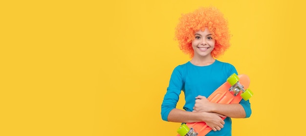 Fröhliches Teenager-Mädchen in ausgefallener Clownperücke hält Penny-Board-Aktivität Lustiges Teenager-Kind auf Party-Poster-Banner-Header mit Kopierbereich