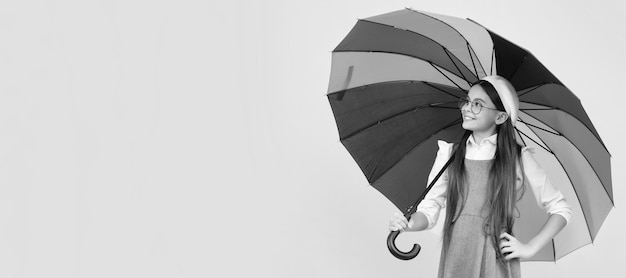 Fröhliches Teenager-Mädchen unter buntem Regenschirm zum Schutz vor Regen in der Herbstsaison Kind mit Herbstregenschirm Regenwetter horizontales Plakatbanner mit Kopierraum