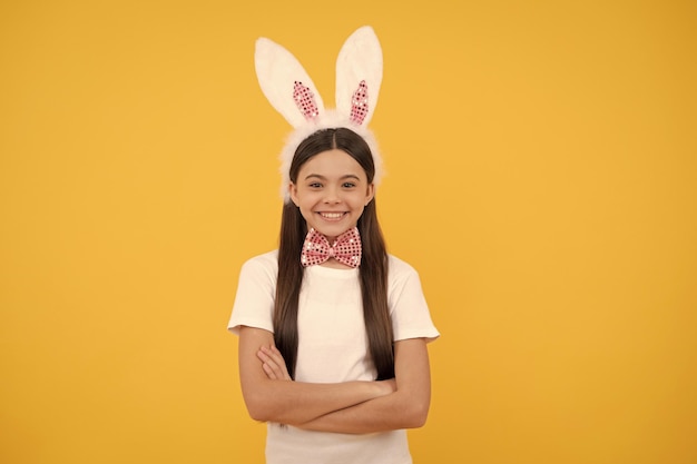 Fröhliches Teenie-Mädchen zu Ostern in Hasenohren und Fliege Ostern