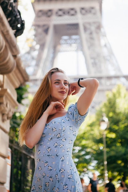 Fröhliches und glückliches Mädchen in der Nähe des Eiffelturms in Paris