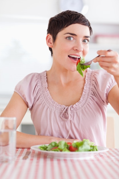Frohe Frau, die Salat isst