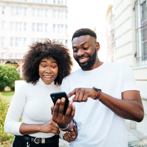 Foto frohe freunde, die mobile betrachten