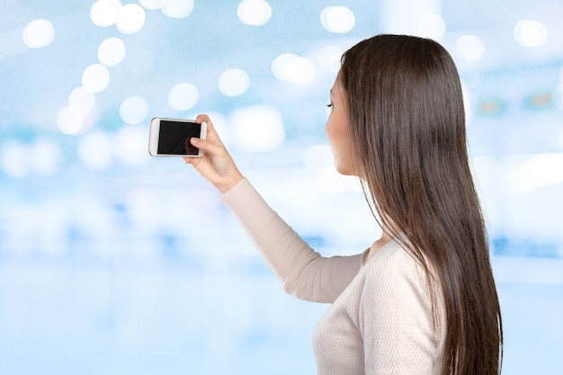 Frohe junge Frauen, die selfie durch ihr intelligentes Telefon machen