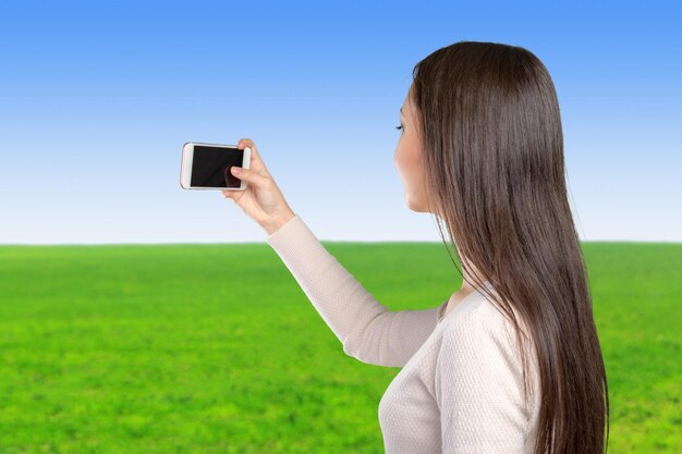 Frohe junge Frauen, die selfie durch ihr intelligentes Telefon machen