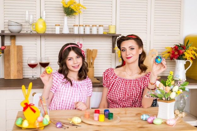 Frohe Ostern Eine Mutter und ihre Tochter, die Ostereier malen Glückliche Familie, die sich auf Ostern vorbereitet