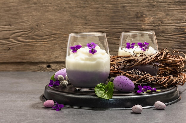 Frohe Ostern festliche Zusammensetzung Veganes Panna-Cotta-Dessert mit frischer Veilchenblume