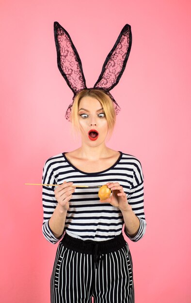 Foto frohe ostern ostertag osterei osterhase frau mit malpinsel überrascht frau