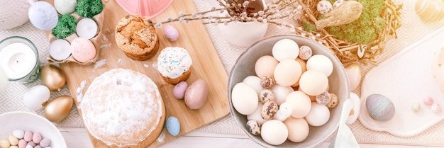 Frohe ostern und frühlingsferien zeit festliche tischlandschaft set dekor traditionelles abendessen essen ostereier und gebackene kuchen auf dem tisch zu hause blass pop pastellblau und rosa farbe draufsicht banner flare