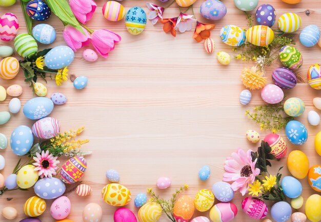 Frohe Ostertag bunte Eier und Blumendekoration auf Holz