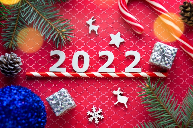 Frohe Weihnachten 2022 Zahlen 2022 mit Neujahrssüßigkeiten und Weihnachtsbaum Neujahrskonzept