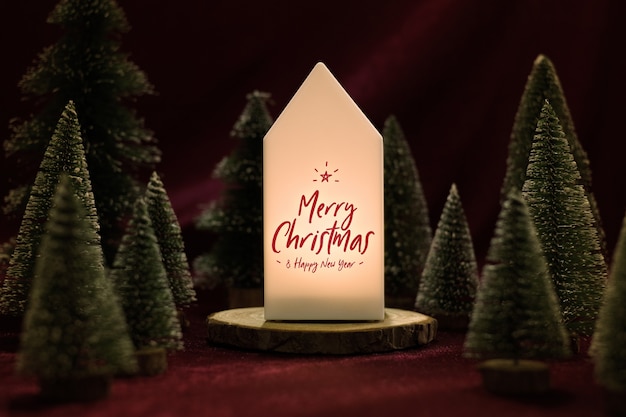 Frohe Weihnachten auf Hauptlampe mit Weihnachtsbaum auf Samtgewebetisch in der dunklen Nacht