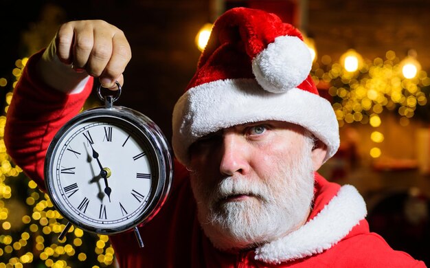 Foto frohe weihnachten, frohes neujahr, zeit, den ernsthaften weihnachtsmann mit weckervorbereitung zu feiern.