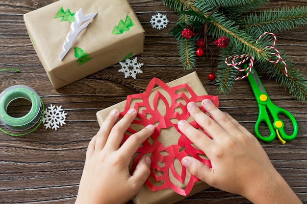 Frohe Weihnachten-Konzept Verpacken von Weihnachtsgeschenken in handgefertigten Kisten auf Holztisch