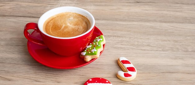 Frohe Weihnachten mit hausgemachten Keksen und Kaffeetasse auf Holztischhintergrund. Weihnachtsabend-, Party-, Feiertags- und Frohes neues Jahr-Konzept