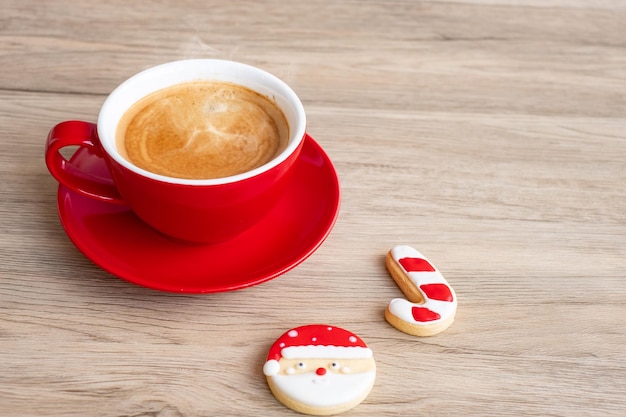 Frohe Weihnachten mit hausgemachten Keksen und Kaffeetasse auf Holztischhintergrund Weihnachtsfeier und frohes neues Konzept