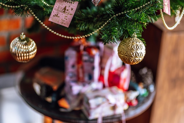 Frohe Weihnachten, Nahaufnahme von bunten Kugeln, Geschenkbox und Weihnachtsgrußbild Paketdekoration auf grünem Weihnachtsbaum Hintergrund Dekoration während Weihnachten und Neujahr.