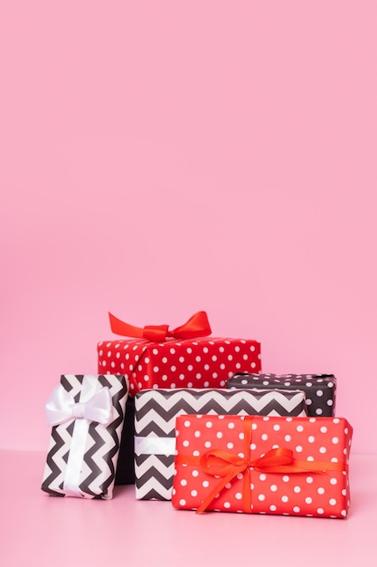 Frohe Weihnachten, neues Jahr und Verkaufsveranstaltungskonzept Geschenkboxen mit Schleife auf rosa Hintergrund