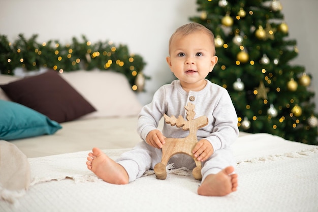 Frohe Weihnachten Porträt eines süßen kleinen einjährigen Mädchenbabys in einem gemütlichen Schlafzimmer, das sich für den Feiertagslebensstil verkleidet hat