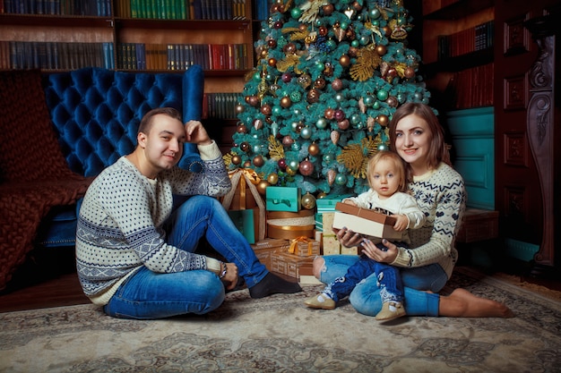 Frohe Weihnachten und ein glückliches Neues Jahr! Glückliche Familie, die zu Hause Winterurlaub feiert