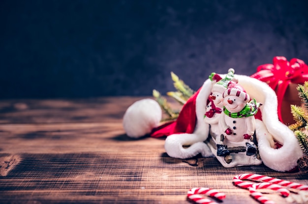 Frohe Weihnachten und ein glückliches Neues Jahr. Wintersaison-Feiertagsdekoration auf Holzhintergrund.