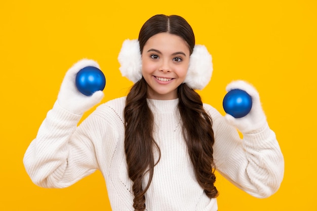 Frohe Weihnachten und glückliches neues Jahr Kid in Winterkleidung Teen Mädchen mit dekorativen Weihnachtskugel Glückliches Gesicht positive und lächelnde Emotionen von Teenager-Mädchen