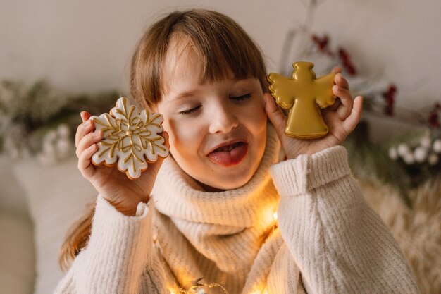 Frohe Weihnachten und schöne Feiertage. Das Kind spielt mit Lebkuchen. Warten auf Weihnachten.