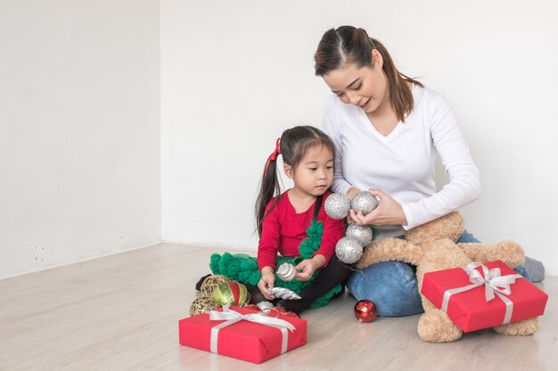 Frohe Weihnachten und schöne Feiertage! Mutter und Tochter dekorieren.