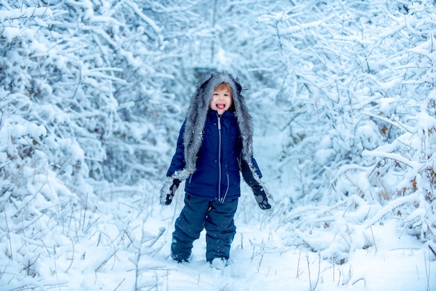 Frohe Weihnachten und schöne Feiertage Winterkind kleines Kind im Schneefeld, das Naturwinter genießt...