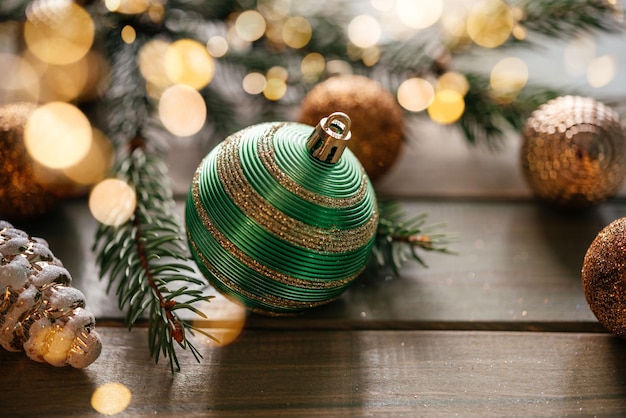 Foto frohe weihnachts-grüßkarte mit grünen weihnachten-kugeln und kiefernzweigen