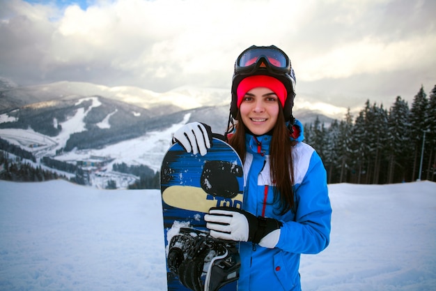 Froher Frauensnowboarder im Winter am Skiort