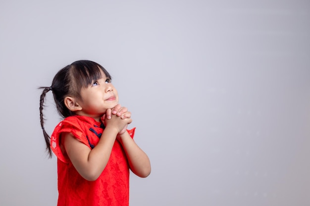 Frohes chinesisches neues Jahr. Kleine asiatische Mädchen mit Glückwunschgeste