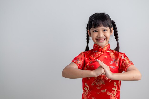 Frohes chinesisches neues Jahr. Kleine asiatische Mädchen mit Glückwunschgeste