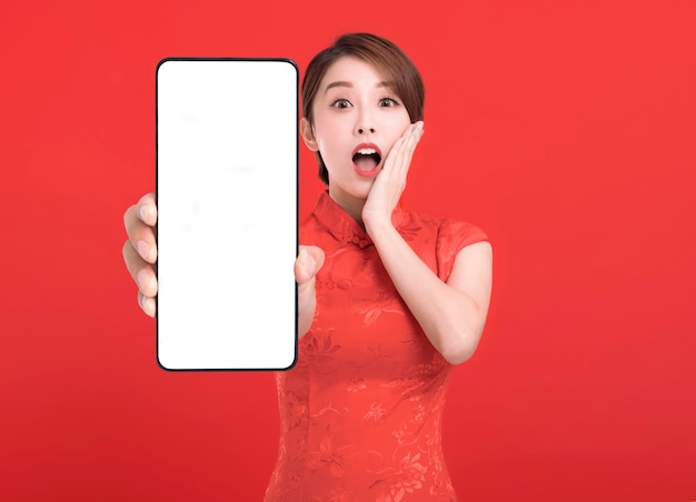 Frohes chinesisches Neujahr überraschte junge Frau, die einen leeren Smartphone-Bildschirm zeigt