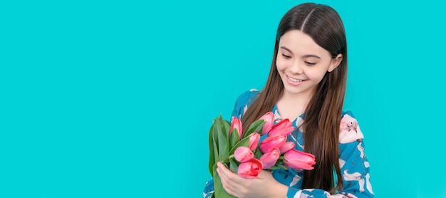 Frohes Kind hält Blumen für den 8. März. Teenager-Mädchen mit Frühlingsstrauß auf blauem Hintergrund. Banner mit Frühlingskind, Mädchen mit Tulpen-Blumenstrauß, Studioporträt mit Kopierraum