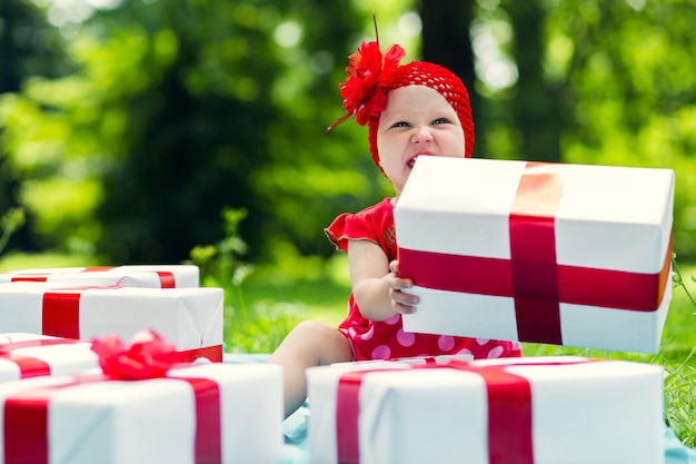 Frohes Kindermädchen mit bunten Geschenkboxen