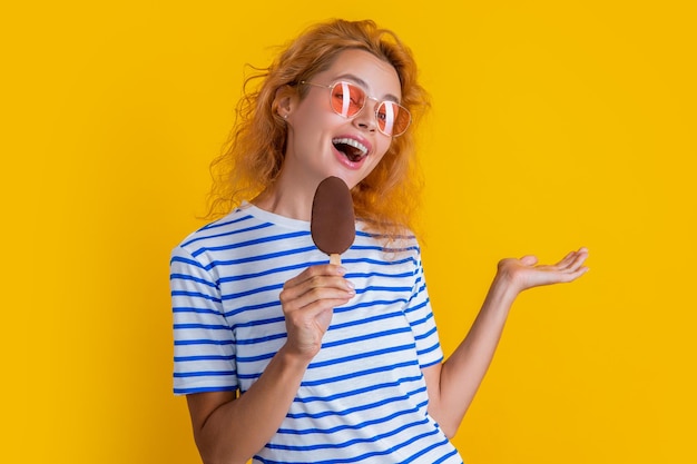 Frohes Mädchen mit leckerem Eis im Studio Mädchen mit leckerem Eis im Hintergrund