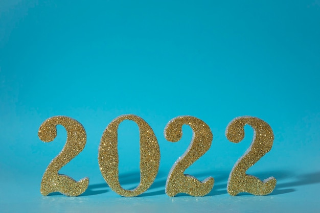 Foto frohes neues jahr 2022 in goldfarbe mit blauem hintergrund und platz für text