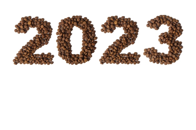 Foto frohes neues jahr 2023 haustiere text 2023 bestehend aus trockenem, knusprigem hunde- oder katzenfutter auf weißem hintergrund