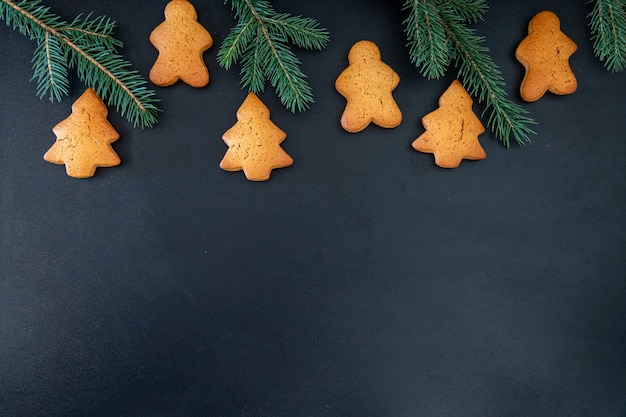 Frohes neues Jahr Lebkuchen aus Ingwerkeksen Mann glasierte Zuckerglasur Dekoration auf schwarzem Hintergrund, minimale saisonale Pandemie Winterurlaub Banner