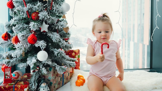 Frohes neues Jahr und Weihnachten Innenfoto süßes Baby und Mutter mit Fichte und Spielzeug