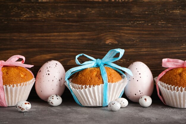 Frohes Osterkonzept. Ostern Cupcakes und Eier auf einer Holzoberfläche, Nahaufnahme.