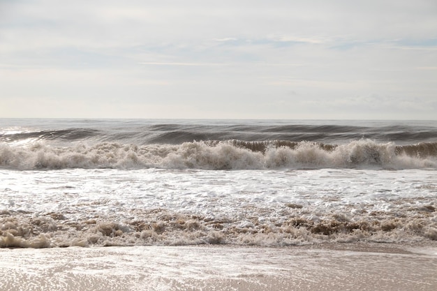 Frontaler Blick auf die Wellen vom Strand. Ein bewölkter Tag.