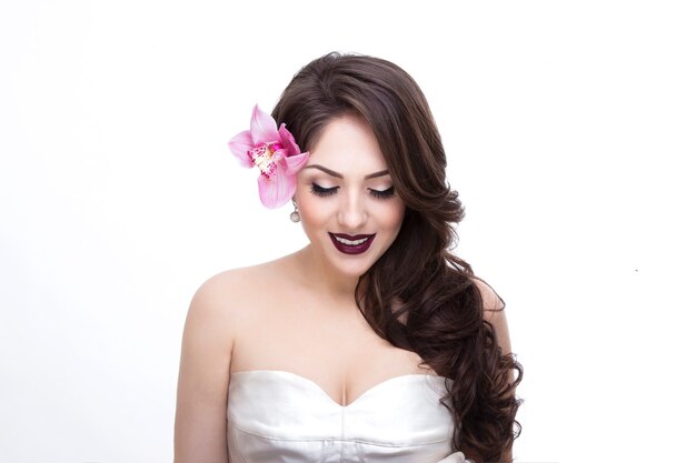 Frontalporträt eines jungen Modells mit geschlossenem Auge und welligem Haar, Braut Make-up und Kleid