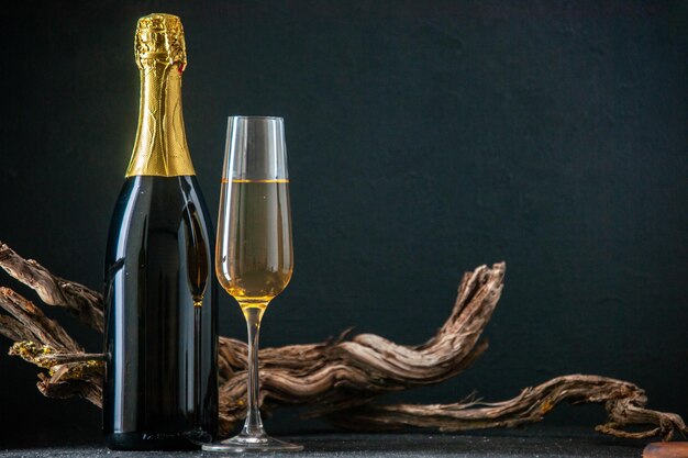 Frontansicht Glas Champagner mit Flasche Champagner auf dunklem Hintergrund Nachtbar trinken Alkohol Café Neujahrsfeier Restaurant