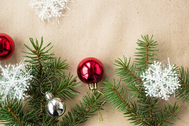 Fronteira de Natal festivo com bolas vermelhas e prata em ramos de abeto e flocos de neve