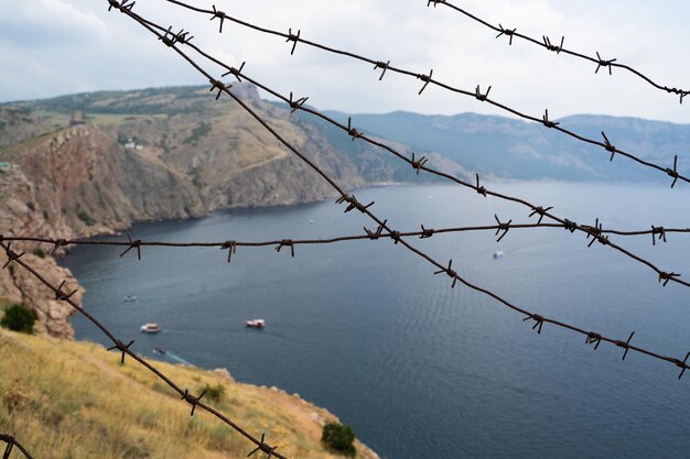 Fronteira militar de arame farpado no mar nas montanhas